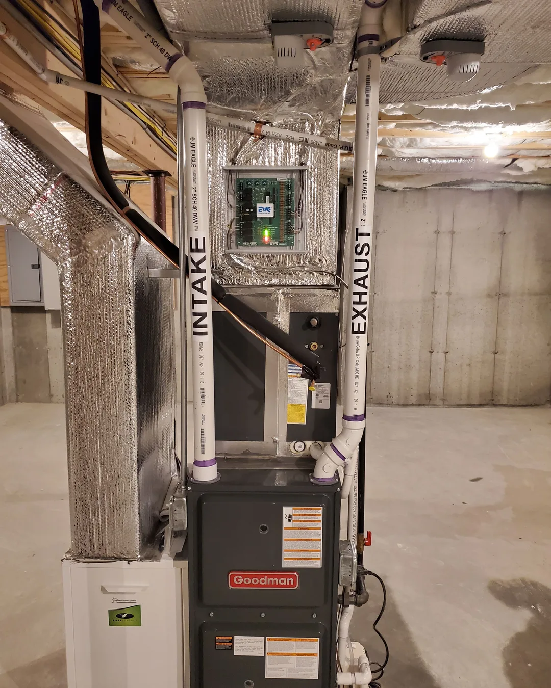 AirPrime furnace and insulated intake and exhaust runs installed in a basement mechanical space